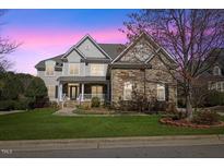 Charming two-story home featuring a landscaped front yard, stone accents, and a welcoming front porch at 404 Vintage Hill Cir, Apex, NC 27539