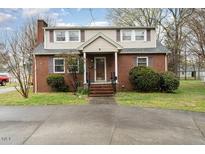 Charming brick home featuring a classic design, well-maintained lawn, and inviting curb appeal at 413 S Maple St, Graham, NC 27253