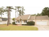 Charming ranch home features a welcoming front porch, attached garage, and beautifully landscaped yard at 45 Crabtree Ct, Fuquay Varina, NC 27526