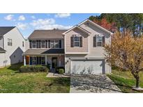 Charming two-story home with a well-manicured lawn, two-car garage and inviting front porch at 5405 Seaspray Ln, Raleigh, NC 27610