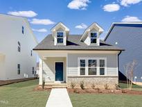 Charming home with a manicured lawn, brick foundation, and dormer windows at 749 Portland Rose Dr, Knightdale, NC 27545