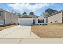 Charming single-story home with a well-manicured lawn and a concrete driveway leading to the attached garage at 909 Sea Holly Dr, Zebulon, NC 27597