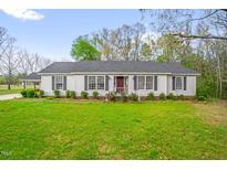 Charming single-story home with a well-maintained lawn, tidy landscaping, and a red front door at 1022 Glover Rd, Dunn, NC 28334