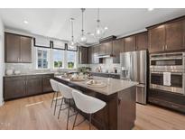 Modern kitchen featuring stainless steel appliances, island with seating, and pendant lighting at 1034 Zelkova Ln, Chapel Hill, NC 27517