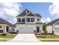 Charming two-story home with a two-car garage, gray accents, and a well-manicured lawn at 104 Fairwinds Dr, Lillington, NC 27546