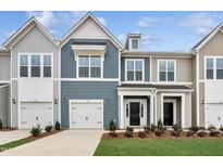 Charming two-story townhome featuring a one car garage, well-maintained lawn, and neutral color siding at 104 Ripple Way # 318, Clayton, NC 27520