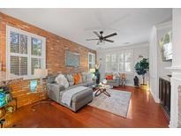 Inviting living room featuring a brick accent wall and plush grey sectional at 10400 Rosegate Ct # 3, Raleigh, NC 27617