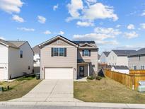 Charming two-story home featuring a two-car garage and neutral siding, complemented by a well-maintained lawn at 1445 Lombar St, Raleigh, NC 27610