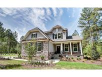 Charming two-story home featuring stone accents, gray siding, well-manicured lawn, and mature trees at 150 Green Haven Blvd # 67, Youngsville, NC 27596