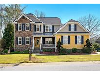 Charming home features a manicured lawn, brick accents, a porch and inviting curb appeal at 2006 Prairie Ridge Ct, Fuquay Varina, NC 27526