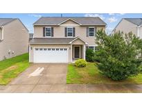 Inviting two-story home featuring a two-car garage and a well-maintained lawn at 2522 Dalmahoy Ln, Fuquay Varina, NC 27526