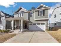 Charming two-story home featuring a two-car garage, landscaped front yard, and covered front porch at 3360 Brevet St, New Hill, NC 27562