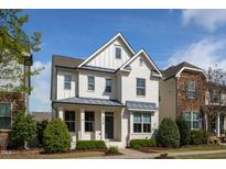 Charming white brick two-story home with blue accents and manicured front yard at 4026 Overcup Oak Ln, Cary, NC 27519