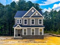 Charming two-story home featuring gray siding, a stone foundation, and a welcoming front porch at 452 Duncan Creek Rd # 156, Lillington, NC 27546