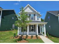Charming two-story home featuring a covered porch and a well-manicured front yard at 728 Georgias Landing Pkwy # 9, Raleigh, NC 27603
