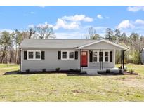 Charming single-story home featuring a red front door and neatly landscaped yard at 8215 S Nc 119 Hwy, Mebane, NC 27302