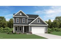 New construction home with a two-car garage, stone accents, and manicured lawn on a sunny day at 1010 Red Roses Ave, Durham, NC 27703