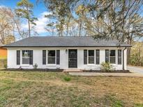 Charming single-story home featuring a white brick exterior, black shutters, and a well-manicured lawn at 1017 E Club Blvd, Durham, NC 27704
