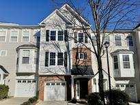 Inviting townhome showcases a charming facade with a private garage and a well-maintained lawn at 106 Madison Square Ln, Cary, NC 27513