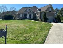 Charming home with manicured lawn, beautiful landscaping, and a welcoming front porch at 1101 Dovefield Ln, Youngsville, NC 27596