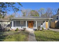 Charming blue-gray home with a welcoming front porch and a beautiful wood front door at 1213 Lincoln St, Durham, NC 27701