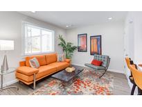 Inviting living room featuring an orange sofa, stylish decor, and an area rug at 1309 Hudson Ave # D2, Durham, NC 27705