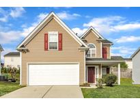 Charming two-story home with tan siding, red shutters, white trim, and a spacious two-car garage at 1320 Rushing Creek Pkwy, Raleigh, NC 27610