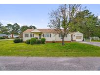 Charming single-story home with a well-maintained lawn and attached garage; perfect for suburban living at 200 N 9Th St, Erwin, NC 28339