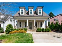 Charming home featuring dormer windows, stone accents, a well-manicured lawn, and a welcoming front porch at 2500 Everett Ave, Raleigh, NC 27607