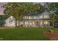 Charming two-story home featuring a covered front porch and attached garage in a lush, green yard at 347 Cook Rd, Elon, NC 27244