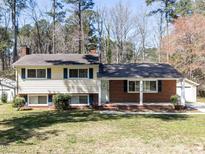 Charming home with light siding and a brick accent wall, complemented by dark shutters and a well-manicured lawn at 3818 Hillgrand Dr, Durham, NC 27705