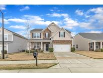 Inviting two-story home featuring a stone facade, attached garage, and well-manicured lawn at 3925 Massey Pointe Ct, Raleigh, NC 27616