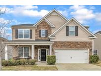 Charming two-story home with a stone and siding exterior, complemented by a two-car garage and manicured landscaping at 3925 Massey Pointe Ct, Raleigh, NC 27616