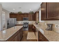 Well-equipped kitchen featuring granite countertops, stainless steel appliances, and wooden cabinetry at 3925 Massey Pointe Ct, Raleigh, NC 27616