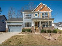 Charming two-story home with blue siding, stone accents, attached garage and beautifully landscaped front yard at 5347 Cypress Ln, Raleigh, NC 27609