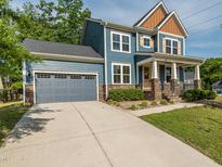 Charming two-story home featuring a covered front porch and a two-car garage with stone accents at 5347 Cypress Ln, Raleigh, NC 27609