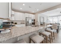 Bright kitchen featuring granite countertops, stainless steel appliances, and an island with bar seating at 600 Hedrick Ridge Road # 112, Cary, NC 27519