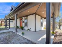 Inviting covered front porch featuring decorative plants and a vibrant orange front door at 602 Gray Ave, Durham, NC 27701