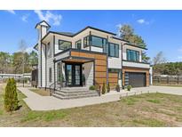 Stunning modern two-story home with stylish black framed windows and a welcoming entryway at 73 Clyde Pearce Rd, Zebulon, NC 27597