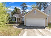 Charming, single-story home with a two-car garage, manicured lawn and sidewalk to the front door at 9512 Anson Grove Ln, Raleigh, NC 27615