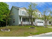 Inviting two-story home with a charming front porch, well-maintained lawn, and attached two-car garage at 1 Serenity Ct, Durham, NC 27704