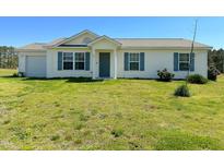 Inviting single-story home with blue shutters, a well-manicured lawn, and an attached garage at 10 Chaney Ln, Louisburg, NC 27549