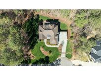 Stunning aerial view of a landscaped home featuring a circular driveway and back patio with a cozy fire pit at 1009 High Trail Ct, Wake Forest, NC 27587