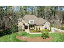 Beautiful brick and stone home with manicured lawn and mature trees at 1009 High Trail Ct, Wake Forest, NC 27587