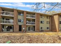 Apartment building with brick accents, multiple balconies, and a well-maintained yard with fallen leaves at 1283 Schaub Dr # B, Raleigh, NC 27606