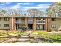 Three story apartment building featuring brick facade and second floor balconies, complimented by a green lawn at 1283 Schaub Dr # B, Raleigh, NC 27606