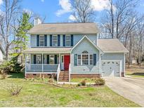 Charming two-story home featuring a cozy front porch, beautiful lawn, and attached garage at 13 Current Ln, Durham, NC 27712