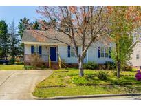 Charming single-story home featuring a cozy porch, blue shutters, and a well-maintained front yard at 133 Grassy Rio Ln, Garner, NC 27529