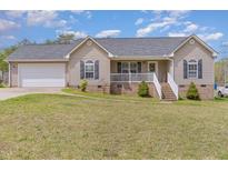 Charming single-Gathering home with light beige siding, complemented by a well-maintained green lawn at 141 Saige Ct, Burlington, NC 27217