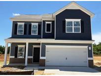 Two-story home featuring a large garage, dark siding, white trim, and black shutters against a blue sky at 144 E Victory View Ter # 66, Smithfield, NC 27577